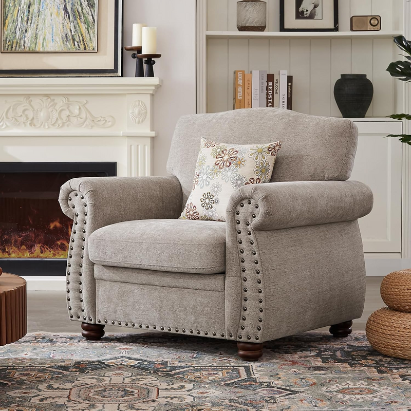 Two gray armchairs with a matching ottoman and a coffee table in a warm living room.