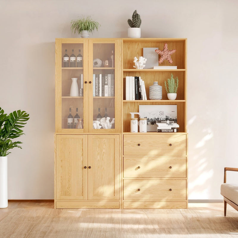 A light wood bookcase with multiple shelves and drawers